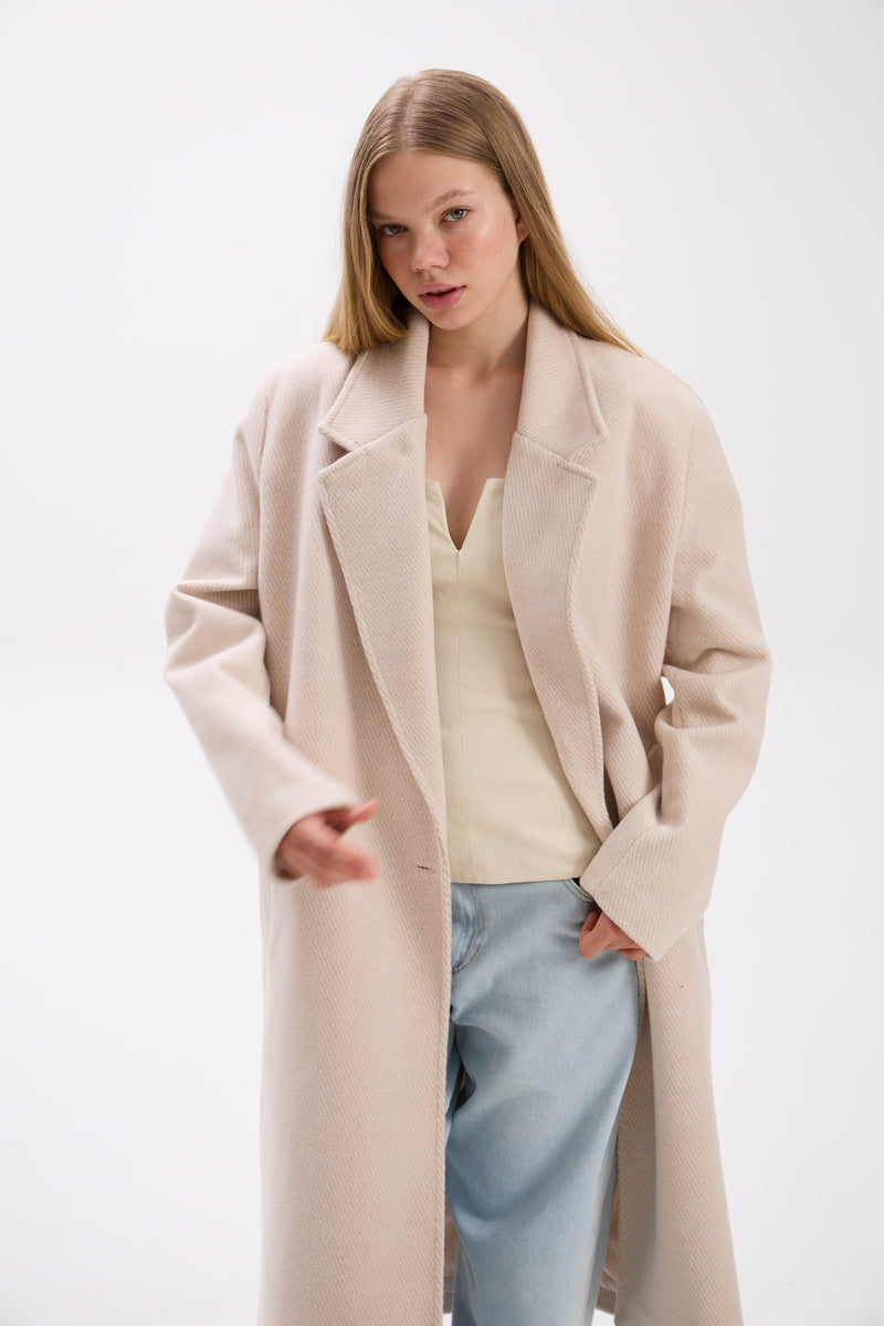 Woman wearing a beige coat on a white background