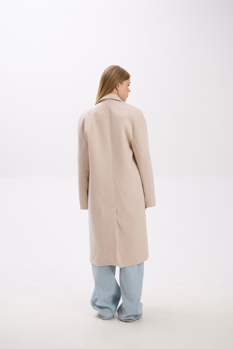 Person wearing a beige coat on a white background
