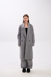 Person wearing a gray coat on a white background