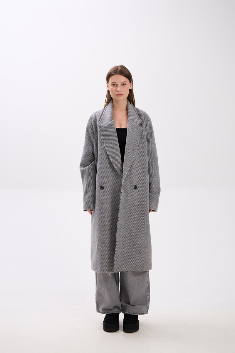Person wearing a gray coat on a white background