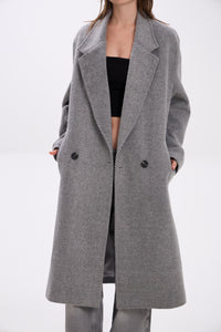 Gray coat worn by a person on a white background