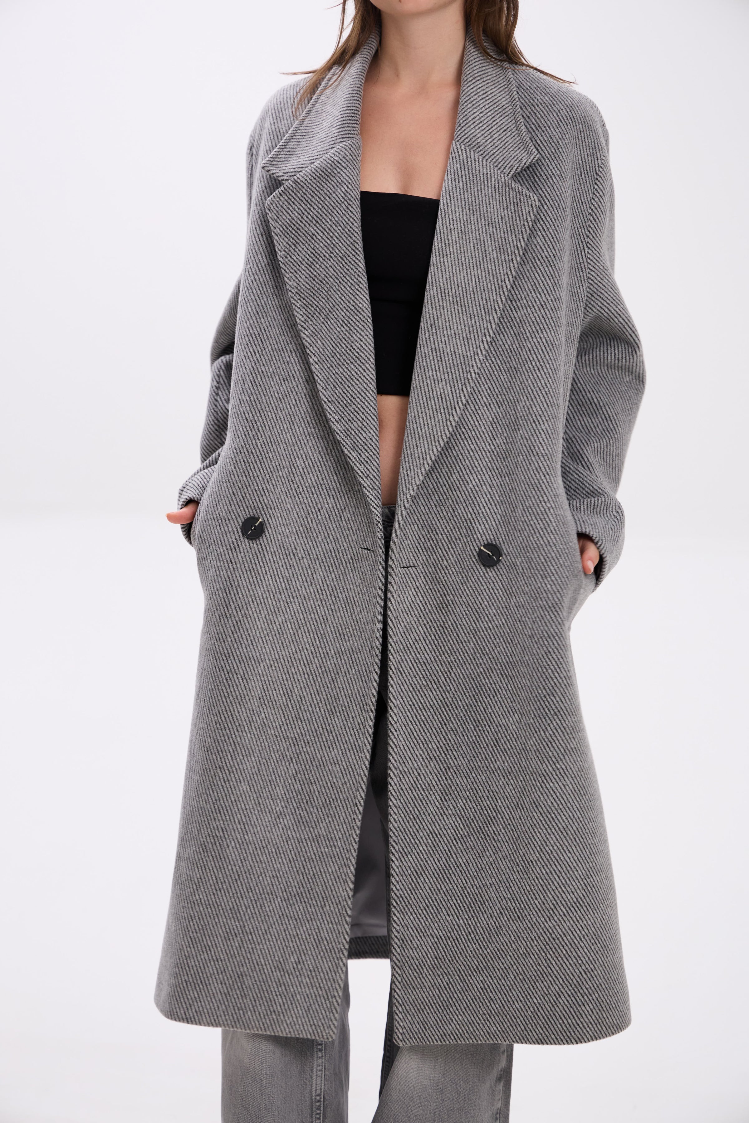Gray coat worn by a person on a white background