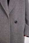 Close-up of a gray textured coat with a button on a white background