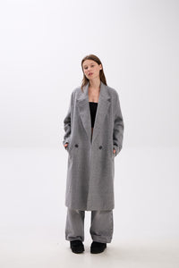 Person wearing a long gray coat on a white background