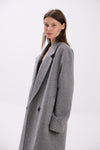 Woman wearing a gray coat on a white background