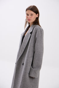 Woman wearing a gray coat on a white background