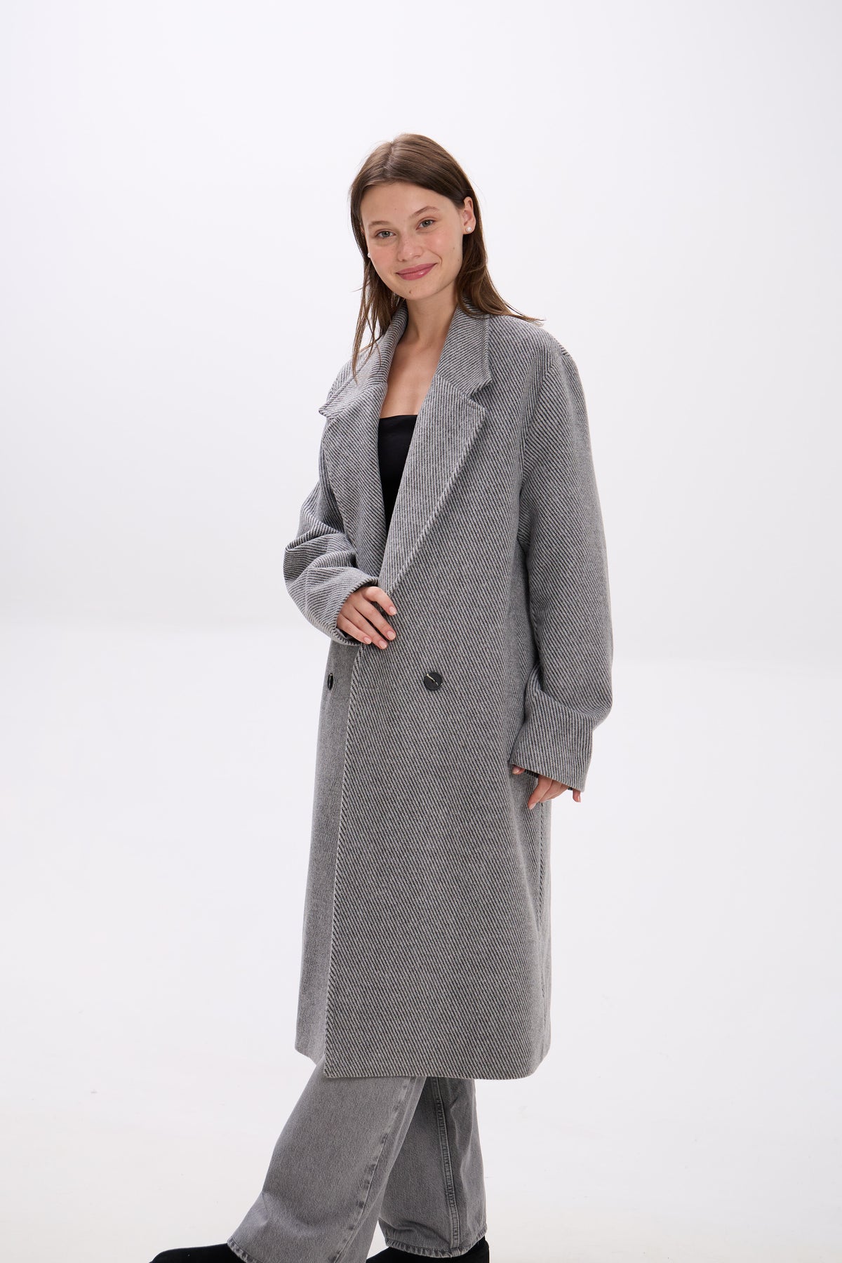 Woman wearing a gray coat on a white background