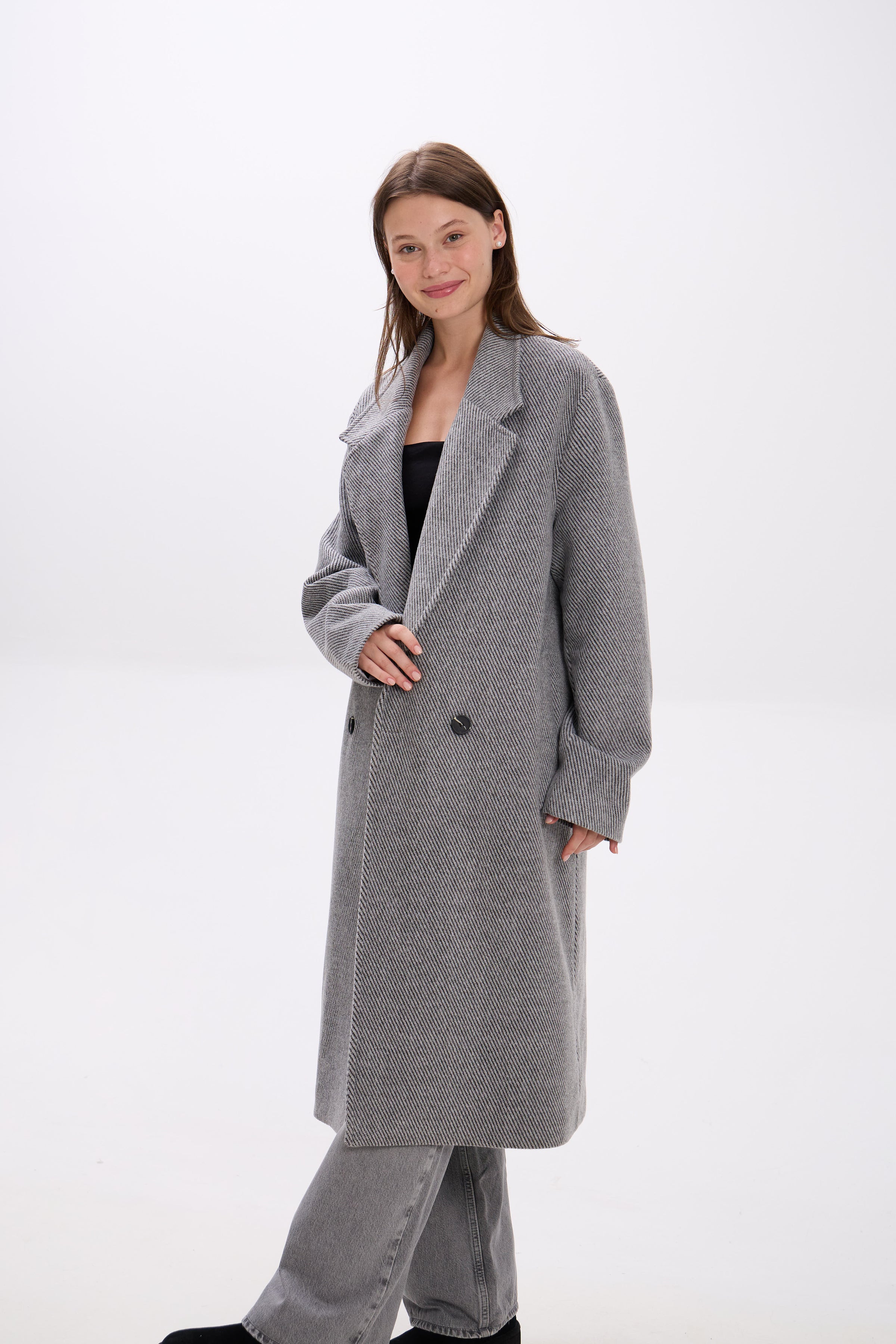 Woman wearing a gray coat on a white background