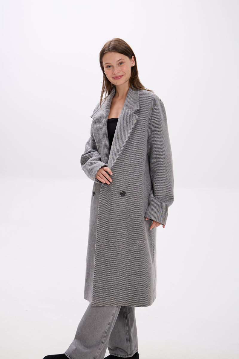 Woman wearing a gray coat on a white background