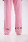Pink straight-leg sweatpants with “Stay Close” leopard print logo detail on the back hem