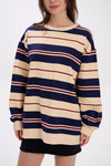 Person wearing a striped sweater dress with navy, beige, and red horizontal stripes on a white background.