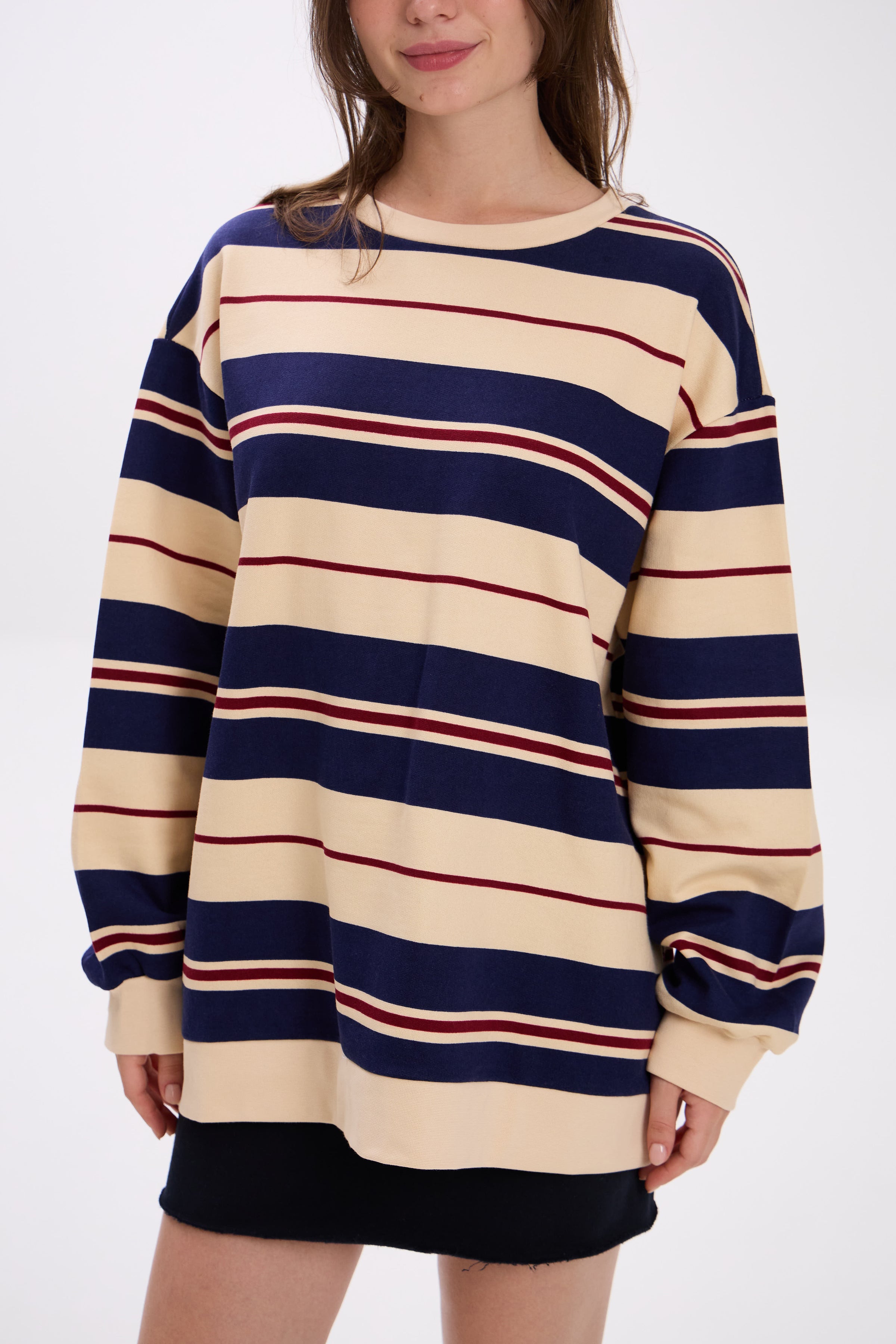 Person wearing a striped sweater dress with navy, beige, and red horizontal stripes on a white background.