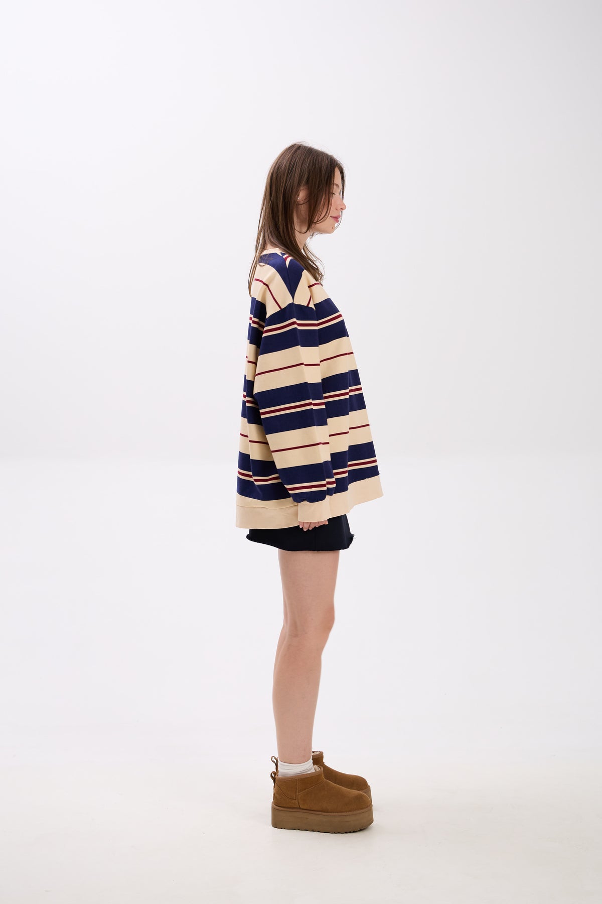 Person wearing a striped sweater and boots on a white background