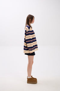 Person wearing a striped sweater and boots on a white background