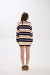 Person wearing a striped sweater dress on a white background