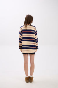 Person wearing a striped sweater dress on a white background