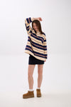 Person wearing a striped sweater and dark skirt on a white background