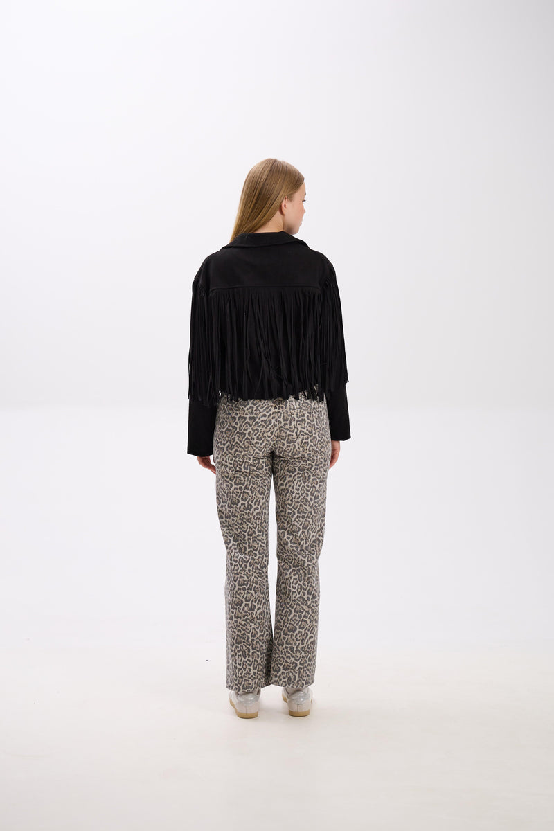 Person wearing a black fringed jacket and patterned pants on a white background.