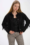 Person wearing a black fringed jacket and leopard print pants on a white background.