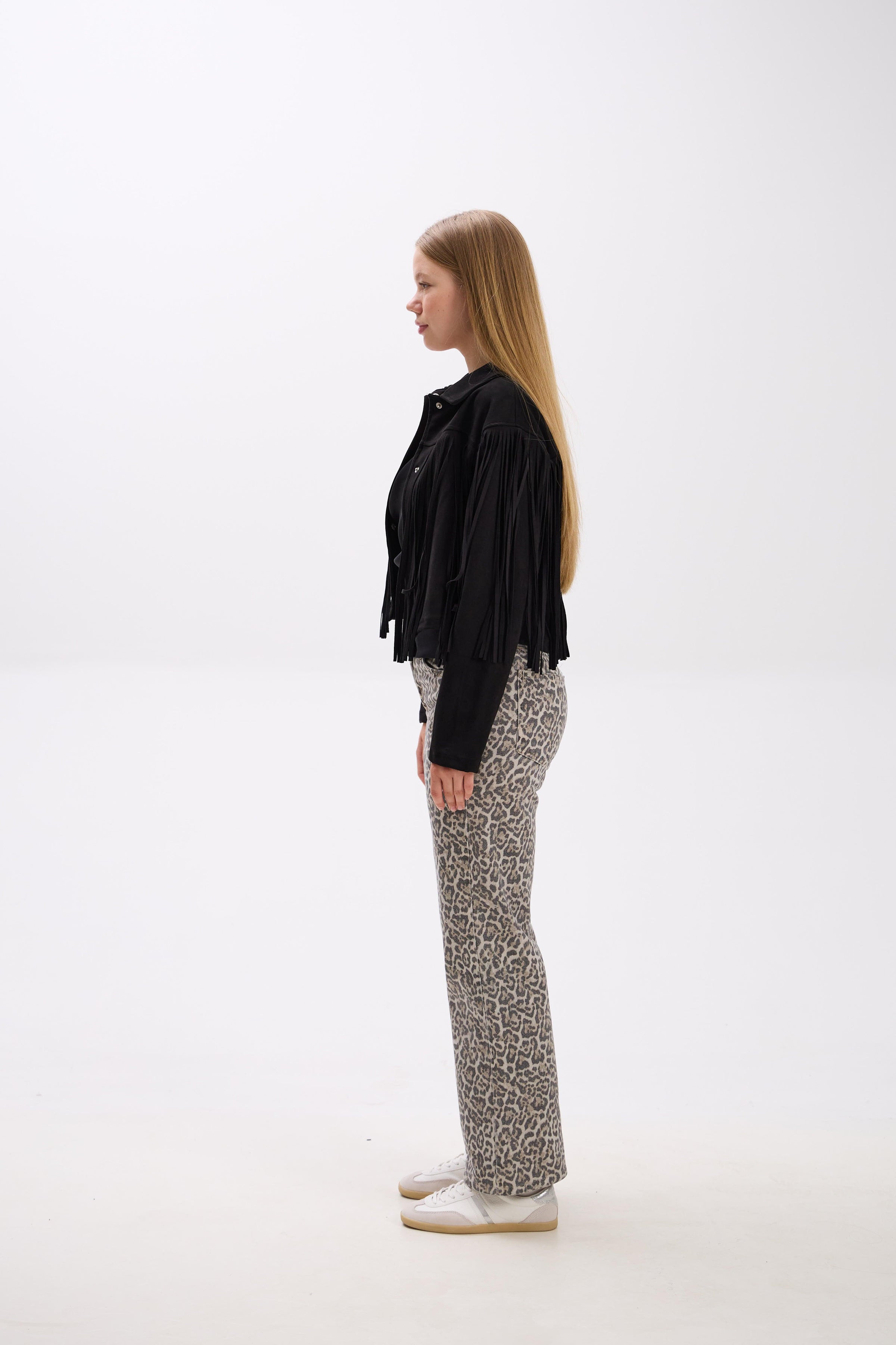 Person wearing a black shirt and patterned pants on a white background.