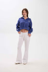 Woman wearing a blue tracksuit with a logo on a white background.