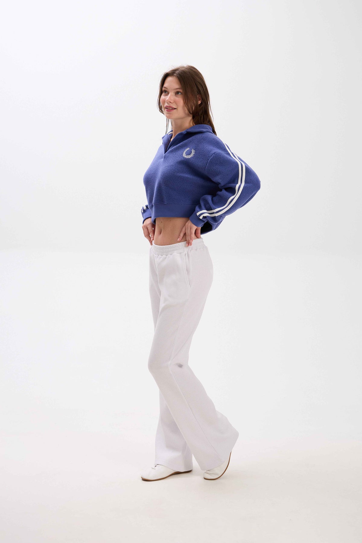 Person wearing a blue tracksuit with white stripes on a white background.