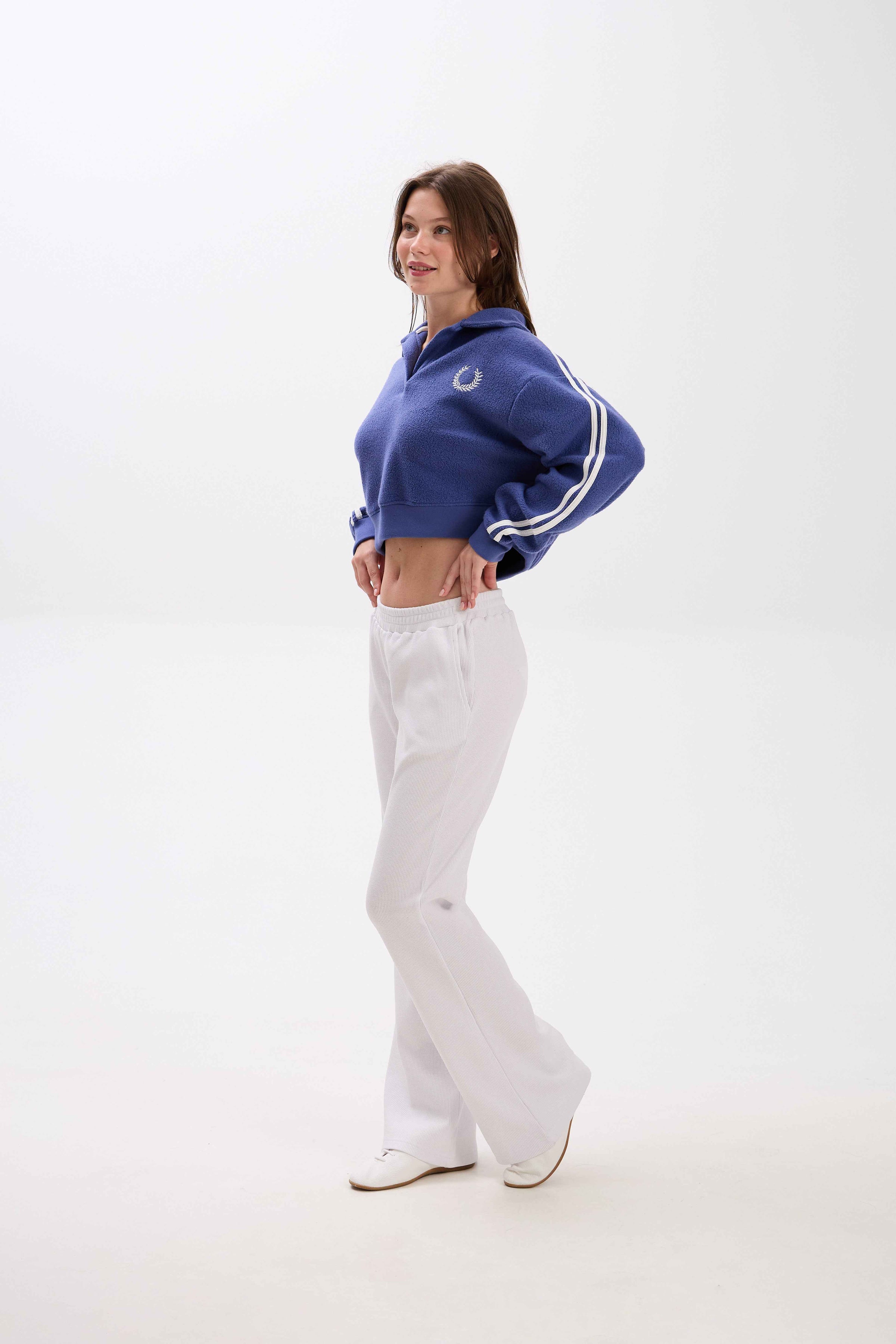 Person wearing a blue tracksuit with white stripes on a white background.