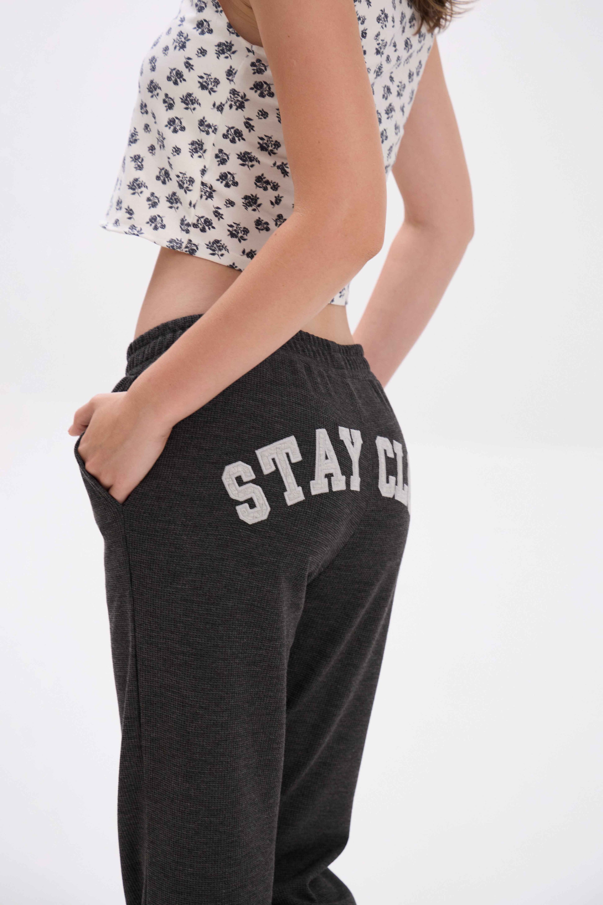 Person wearing black sweatpants with 'STAY CLOSE' text on a white background.