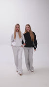 2 girls with hoodies and sweatpants introducing their clothes.