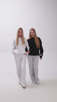 2 girls with hoodies and sweatpants introducing their clothes.