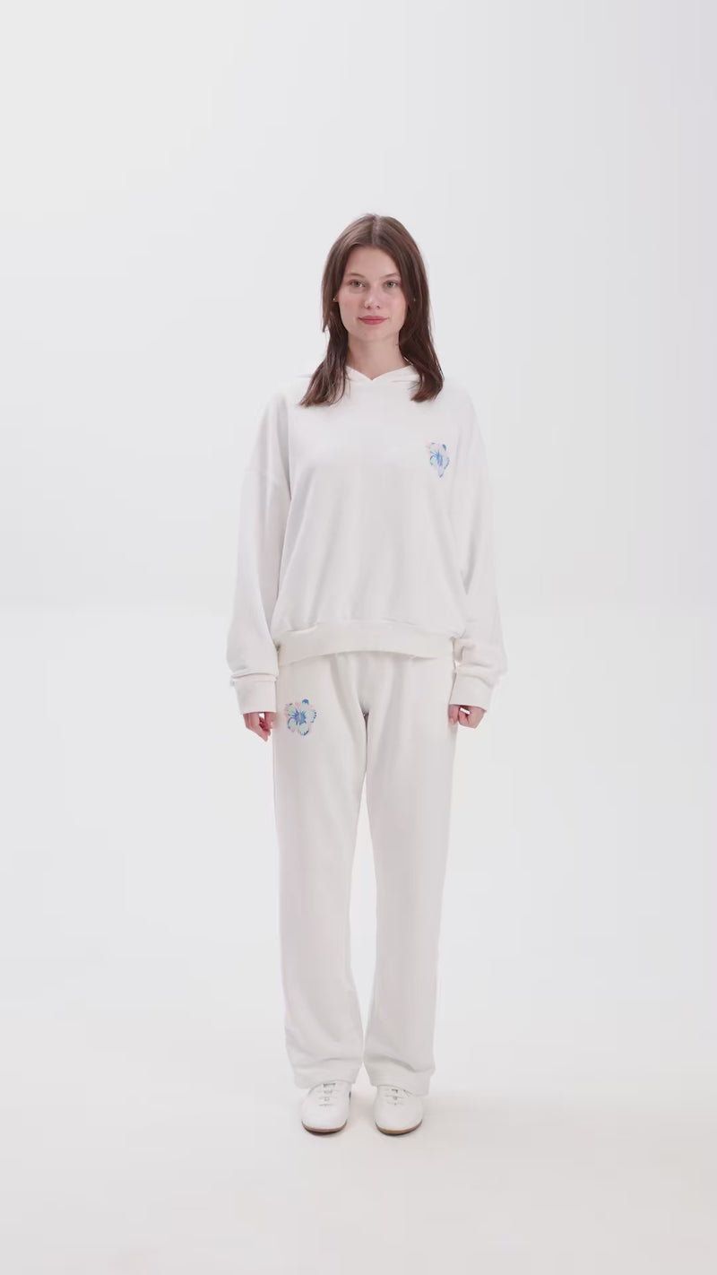 Female model with white sweatshirt and a matching sweatpant on a white background.